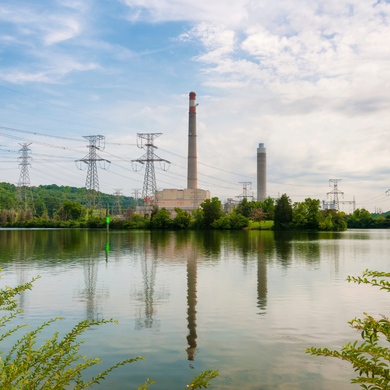 A view of a pond and two industrial smoke stacks in Oak Ridge, Tennessee